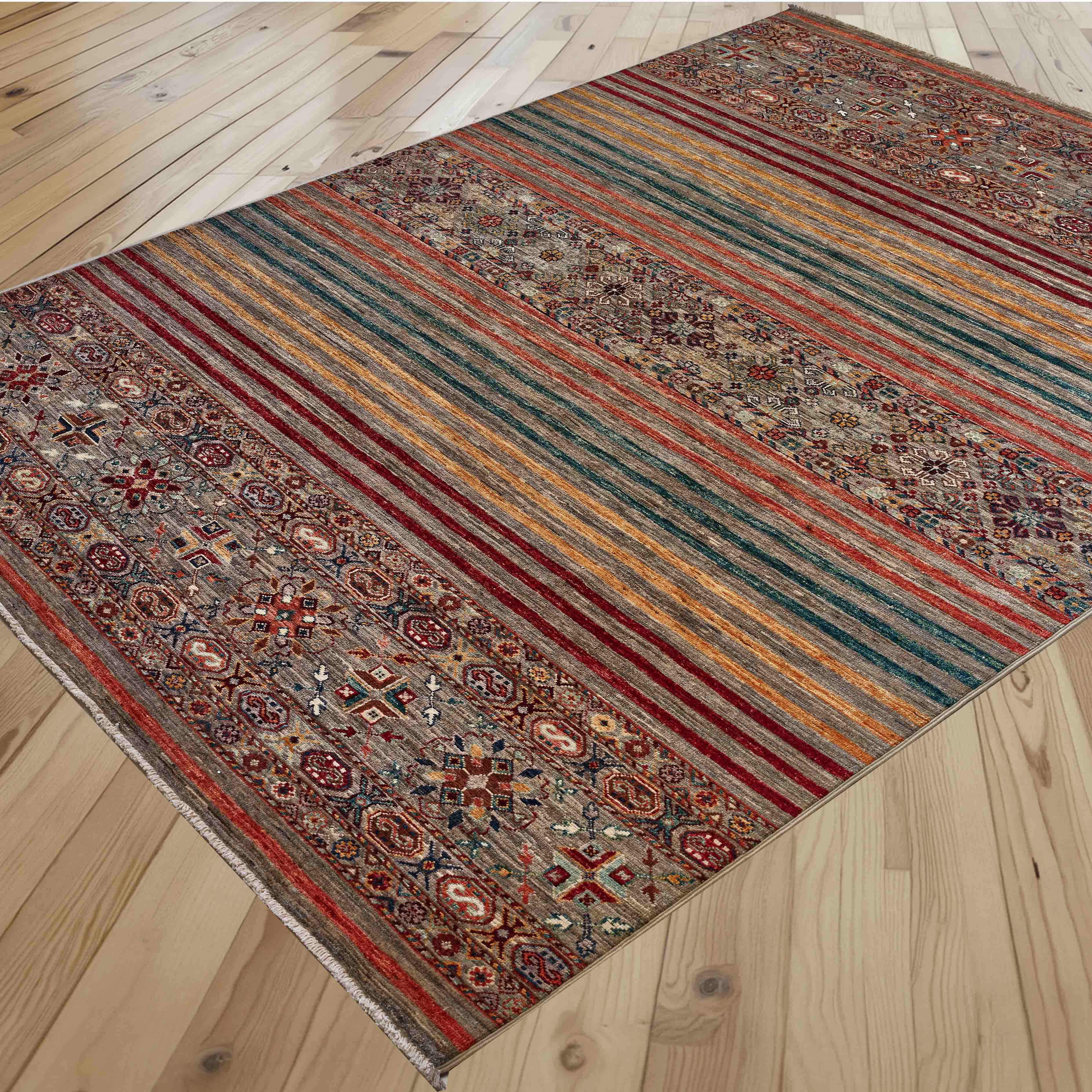 A rectangular Afghan Loribaft rug with a traditional geometric pattern and plain modern stripes in red, green, gold, and orange tones, shown laid out on a light wood plank floor.
